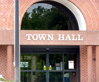 Photo of front of Cromwell town Hall, featuring large arched window above double-door entrance